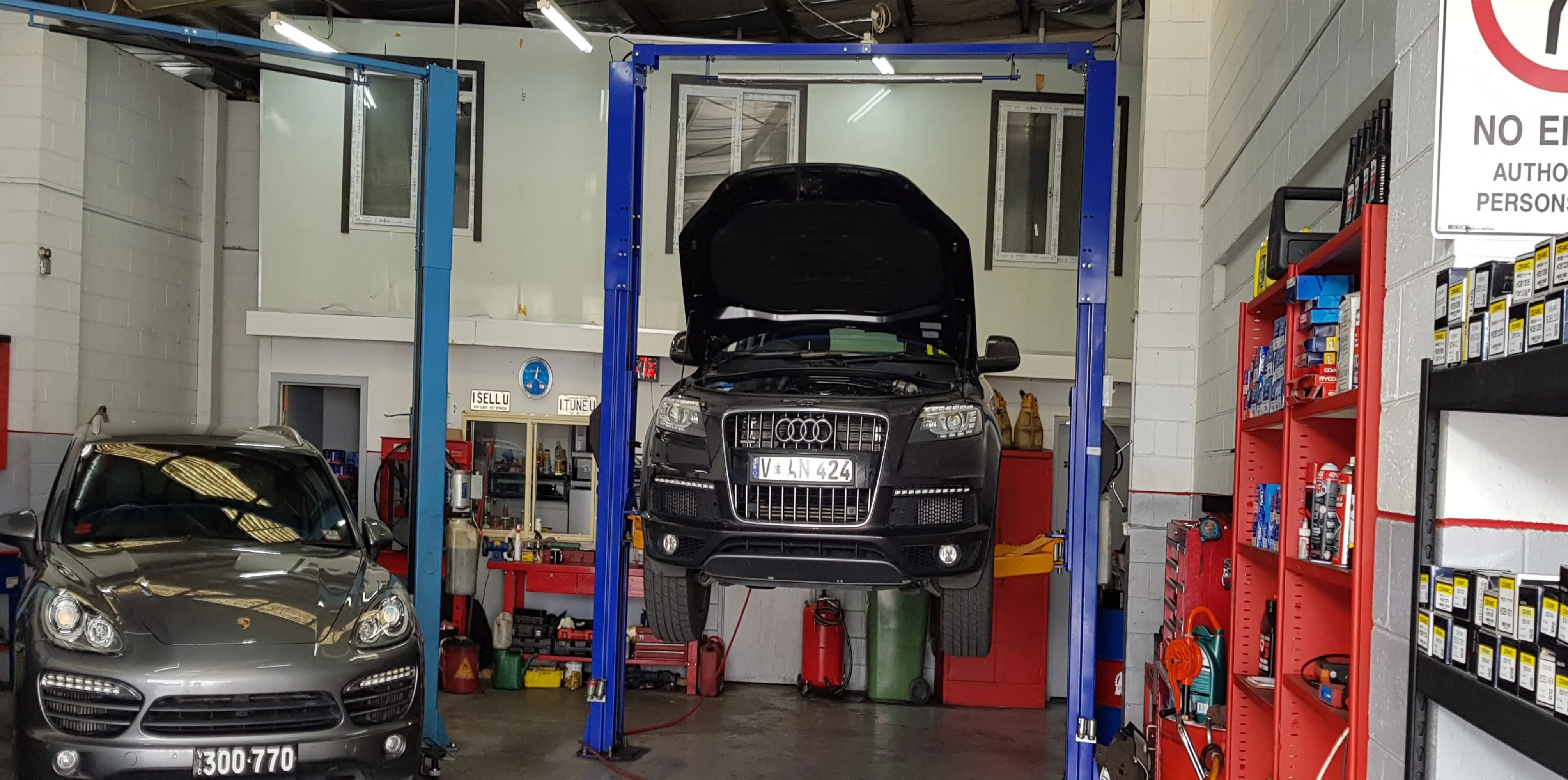 Technician's workshop bay with a vehicle raised on the hoist at Master Auto Service